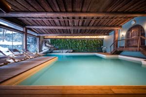 a swimming pool with chairs in a house at Hotel Flüela Davos - The Unbound Collection by Hyatt in Davos