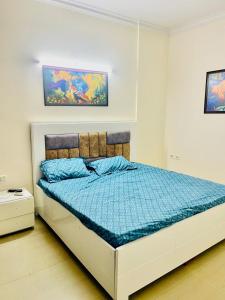 a bedroom with a bed with a blue comforter at Luxury 3 bedroom independent appartment in Ghaziabad