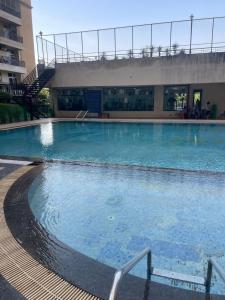 uma grande piscina com água azul em frente a um edifício em Luxury 3 bedroom independent appartment em Ghaziabad