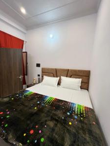 a bedroom with a bed with a colorful blanket on it at Vinayak Homestay in Mathura