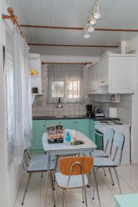 une cuisine avec des placards verts et une table avec des chaises dans l'établissement Lemon Tree House, à Vrahati