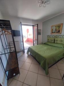 a bedroom with a green bed and a staircase at la casa di Camilla in Volvera