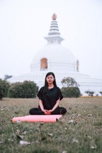 une femme est assise sur un panneau dans l'herbe dans l'établissement Hokke Lumbini, à Rummindei