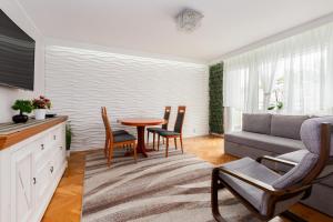 uma sala de estar com uma mesa e cadeiras e um sofá em Seaside Apartment with the View em Gdynia