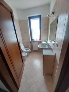 bagno con servizi igienici, lavandino e specchio di la casa di Camilla a Volvera