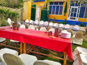 a red table with chairs and plates on it at Rakaposhi Amin Hotel & Restaurant Pissan Hunza Nagar Gilgit Baltistan in Gilgit