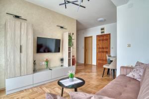 a living room with a couch and a tv on a wall at Apartments Elena in Budva +180 photos