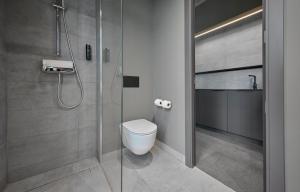 a bathroom with a toilet and a glass shower at Zleep Hotel Zürich-Kloten in Kloten