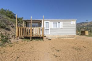a small white house with a porch on a dirt field at Móvil Home Grande in Alós de Balaguer