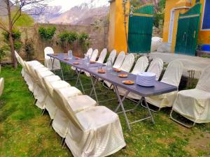 a blue table with white chairs and plates on it at Rakaposhi Amin Hotel & Restaurant Pissan Hunza Nagar Gilgit Baltistan in Gilgit