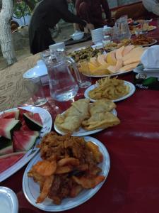 a red table with plates of food on it at Rakaposhi Amin Hotel & Restaurant Pissan Hunza Nagar Gilgit Baltistan in Gilgit