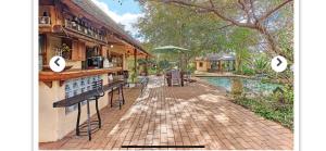 a house with a bar next to a swimming pool at Midrand Wild Goose Guest House B&B in Midrand