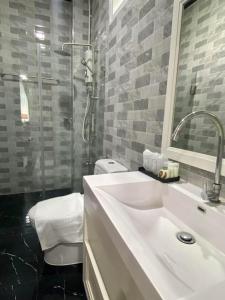 La salle de bains est pourvue d'un lavabo, d'une douche et de toilettes. dans l'établissement ช่องแคบ เดอ เมาท์เท่น รีสอร์ท, à Ban Huai Nam Nak