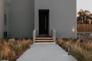 a walkway leading to a door in a building at ONYM Curated Villas in Plaka