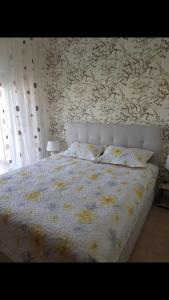- une chambre dotée d'un grand lit avec un couvre-lit floral dans l'établissement Ina's cozy apartment, à Peraia