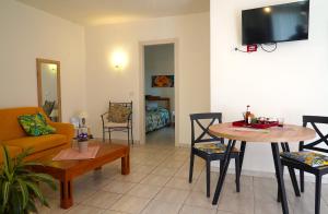 sala de estar con sofá, mesa y sillas en Flowery Inn Villa, en Alghero