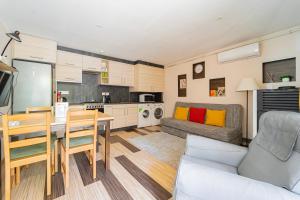 uma cozinha e sala de estar com uma mesa e um sofá em B48 Simplex - egyszinten, kényelmesen em Törökbálint
