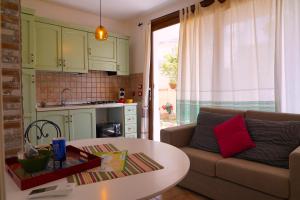 a living room with a couch and a table at Flowery Inn Villa in Alghero