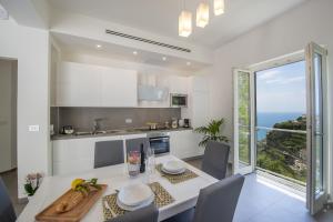 eine Küche mit einem Tisch und einem großen Fenster in der Unterkunft Luxury Villa Donna Rachele in Amalfi