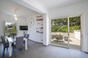 ein Esszimmer mit einem Tisch und einem Fenster in der Unterkunft Luxury Villa Donna Rachele in Amalfi