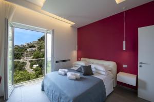 Schlafzimmer mit einem Bett und einem großen Fenster in der Unterkunft Luxury Villa Donna Rachele in Amalfi