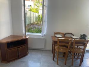 a dining room with a table and chairs and a window at Maison totalement renovée in La Rochelle