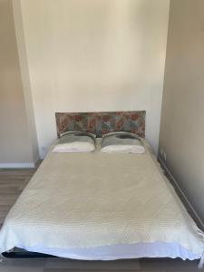a bed with two pillows on it in a room at Maison totalement renovée in La Rochelle