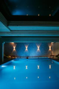 a large swimming pool with lights on the wall at Гетьман Готель & SPA in Chortkiv