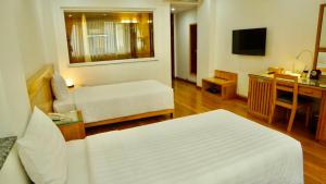 Postel nebo postele na pokoji v ubytování Blue Hanoi Hotel