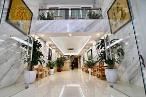 a hallway with chairs and potted plants in a building at Blue Hanoi Hotel in Hanoi