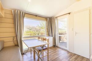 a room with a table and a large window at Móvil Home Pequeña in Alós de Balaguer
