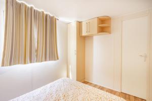 une petite chambre avec un lit et une fenêtre dans l'établissement Móvil Home Pequeña, à Alós de Balaguer