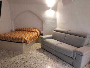 a bedroom with a couch and a bed and a chair at Stone Rooms in Matera