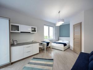 a living room with a bed and a kitchen and a bedroom at Platinium in Karwia