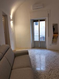 salon z kanapą przed drzwiami w obiekcie Stone Rooms w mieście Matera +33 zdjęcia