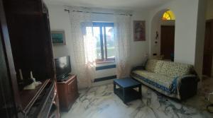 - un salon avec un canapé et une télévision dans l'établissement Casa Chantal, à Fiumaretta di Ameglia