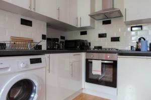 a kitchen with a washer and a washing machine at My Meadows, City Centre Apartment, Sunny&Spacious in Edinburgh
