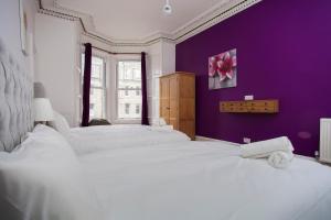 two beds in a bedroom with a purple wall at My Meadows, City Centre Apartment, Sunny&Spacious in Edinburgh