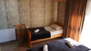 a small bedroom with a bed and a chair at Archil and Nino Gigauri Guest House in Stepantsminda