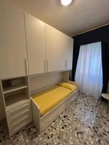 a bedroom with a bed with white cabinets and a window at Hotel Caribe in Viareggio