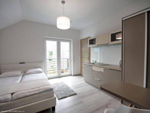 a bedroom with a bed and a table and a kitchen at Platinium in Karwia