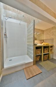 uma casa de banho com um chuveiro e uma banheira em "La Suite" 3 Etoiles em Uzès
