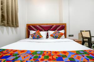 una camera con un letto con una trapunta colorata di FabExpress Akshay a Mumbai