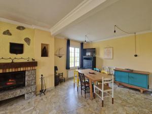 ein Wohnzimmer mit einem Tisch und einem Kamin in der Unterkunft Family-friendly holiday home near the coast in Plougasnou