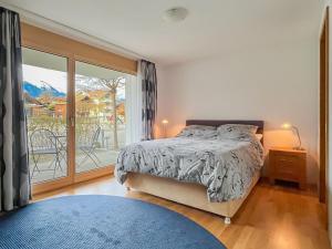 a bedroom with a bed and a large window at Chalet Apartments Iseltwald in Iseltwald