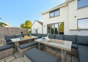 a patio with two tables and blue chairs at Malt Hall in Llanrhidian