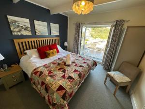 a bedroom with a large bed and a window at The Watermark in Looe