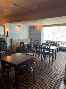a dining room with tables and chairs and a couch at Half Moon Inn in Middlesbrough