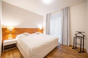 a bedroom with a large white bed and a window at Vila EVA in Luhačovice