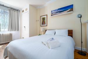 białe łóżko z ręcznikiem w sypialni w obiekcie GuestReady - Former Pub-Turned-One Bedroom Flat w Londynie